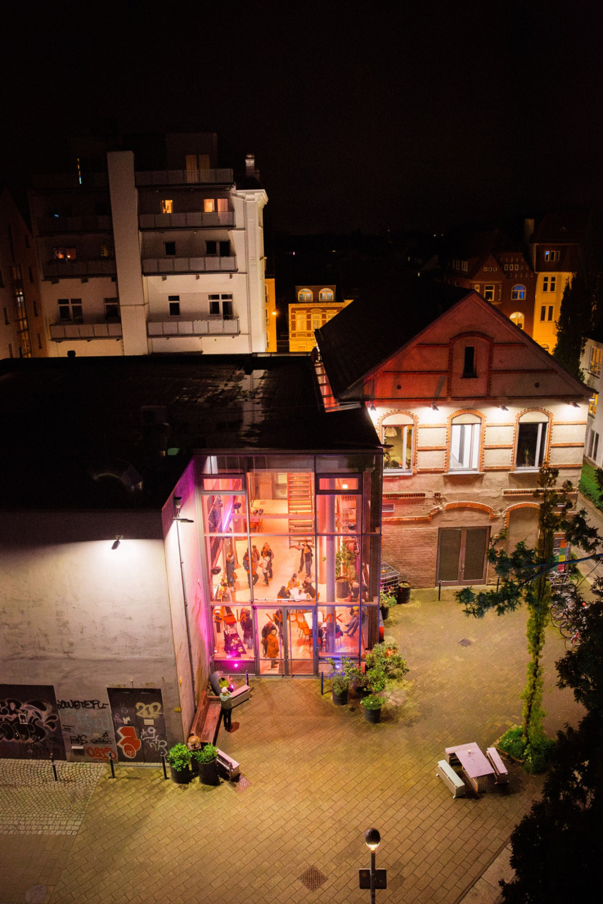 Glasfassade der bunt beuleuchteten Schwankhalle bei Nacht