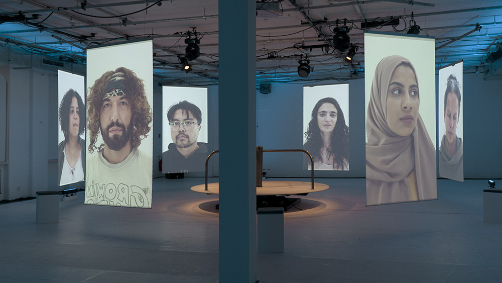 Faces can be seen on projection surfaces suspended in a circle